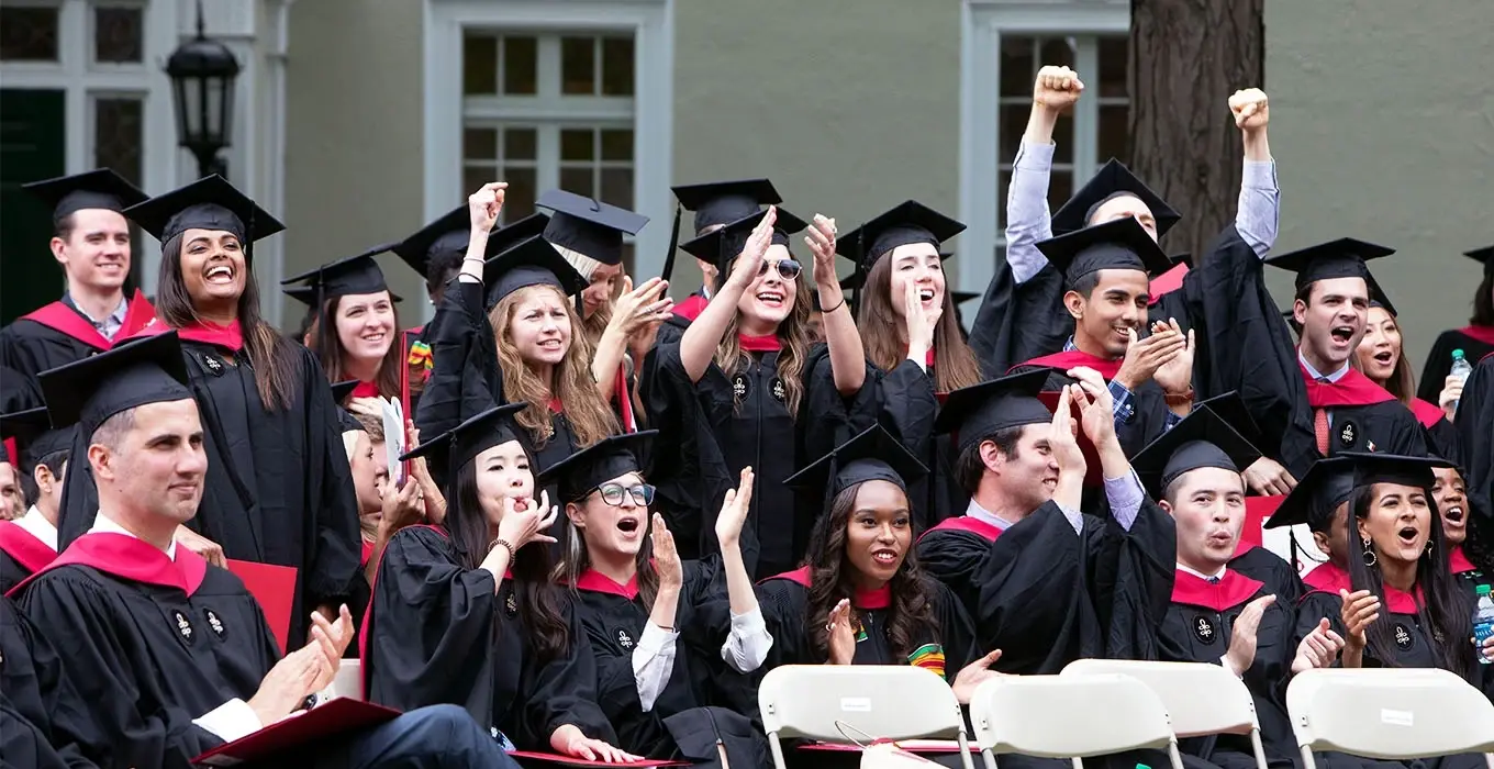 Students in robes and grad caps celebrating.