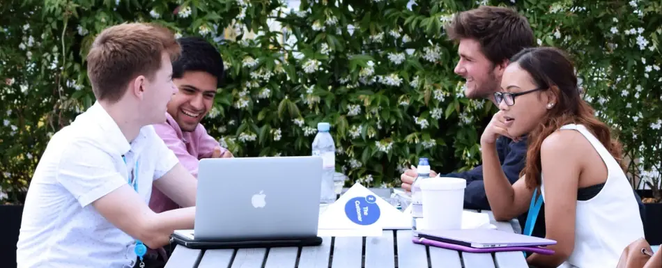 People working together at a table outside.