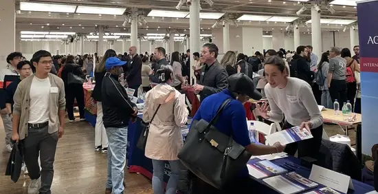 Prospective grad students and admissions representatives talk at an Idealist Grad School Fair.